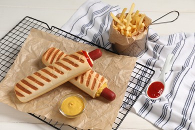 Delicious french hot dogs, fries and dip sauces on white wooden table