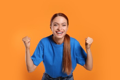 Photo of Excited sports fan celebrating on orange background