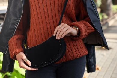 Photo of Fashionable woman with stylish bag on city street, closeup