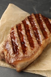 Photo of Delicious grilled beef steak on dark gray table, closeup