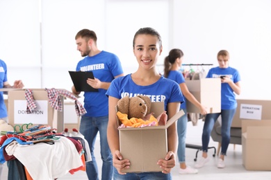 Photo of Female volunteer holding box with donations indoors