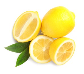 Photo of Cut and whole ripe lemons with green leaves on white background, top view