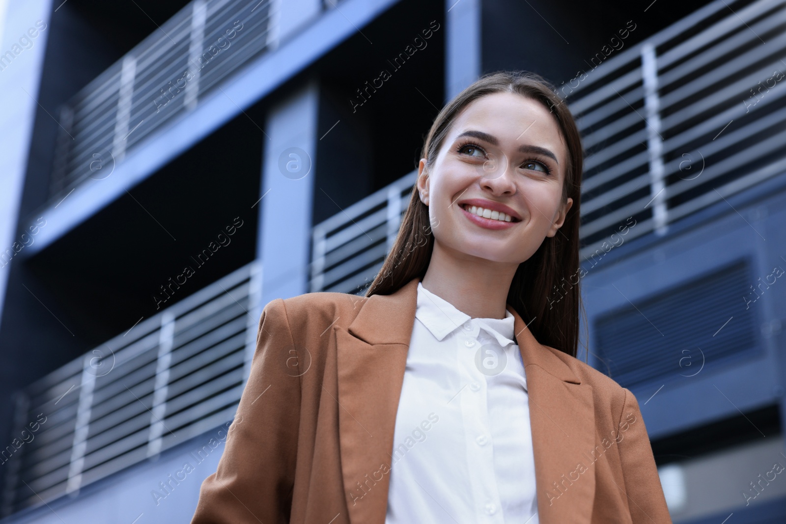 Photo of Young woman in formal clothes near building outdoors, space for text