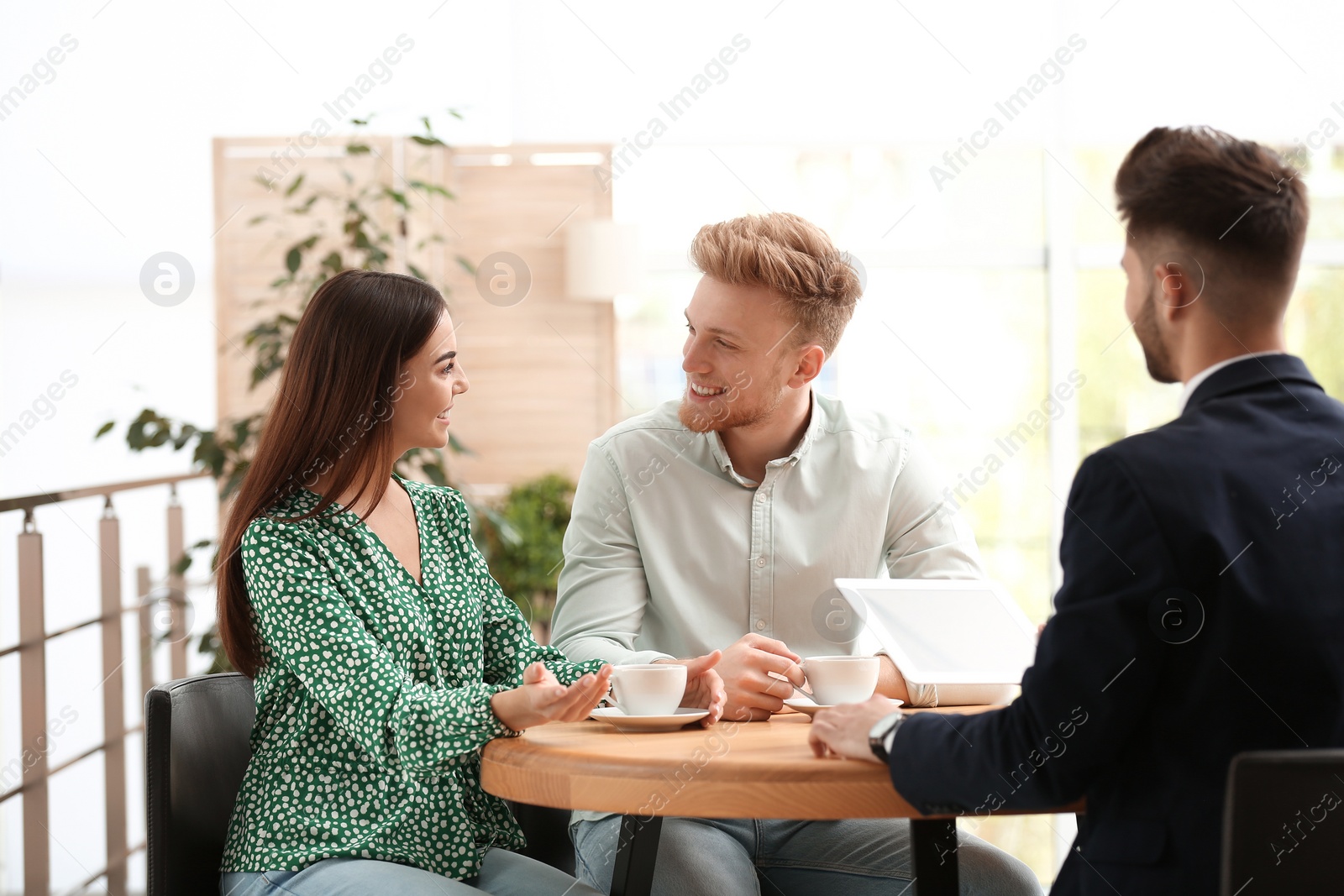 Photo of Insurance agent working with young couple in office