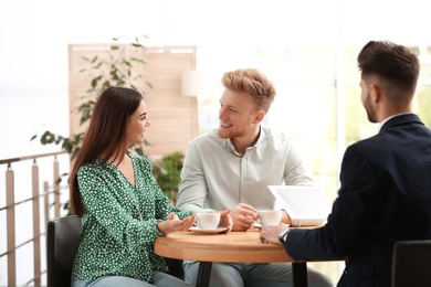 Photo of Insurance agent working with young couple in office