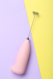 Pink milk frother wand on color background, top view