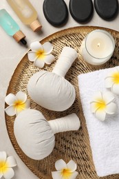 Spa bags, stones and orchid flowers on beige marble table, flat lay