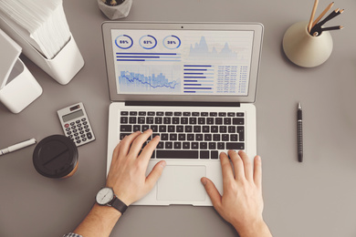 Image of Man using laptop at table, top view. Fintech concept