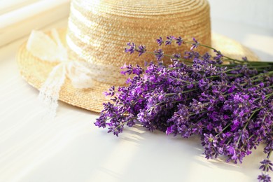 Beautiful lavender flowers and straw hat on window sill, closeup