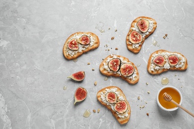 Photo of Bruschettas with cheese and figs on marble table, flat lay. Space for text