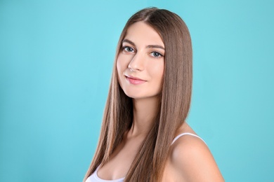 Photo of Portrait of young woman with long beautiful hair on color background