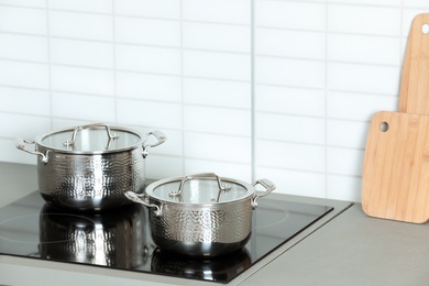 Photo of Clean pans on stove in kitchen. Space for text