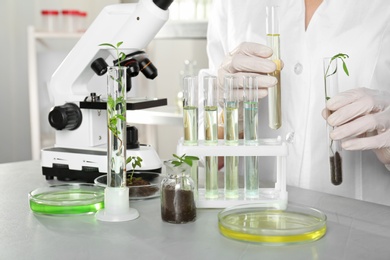 Photo of Analyst with test tubes doing chemical analysis in laboratory, closeup