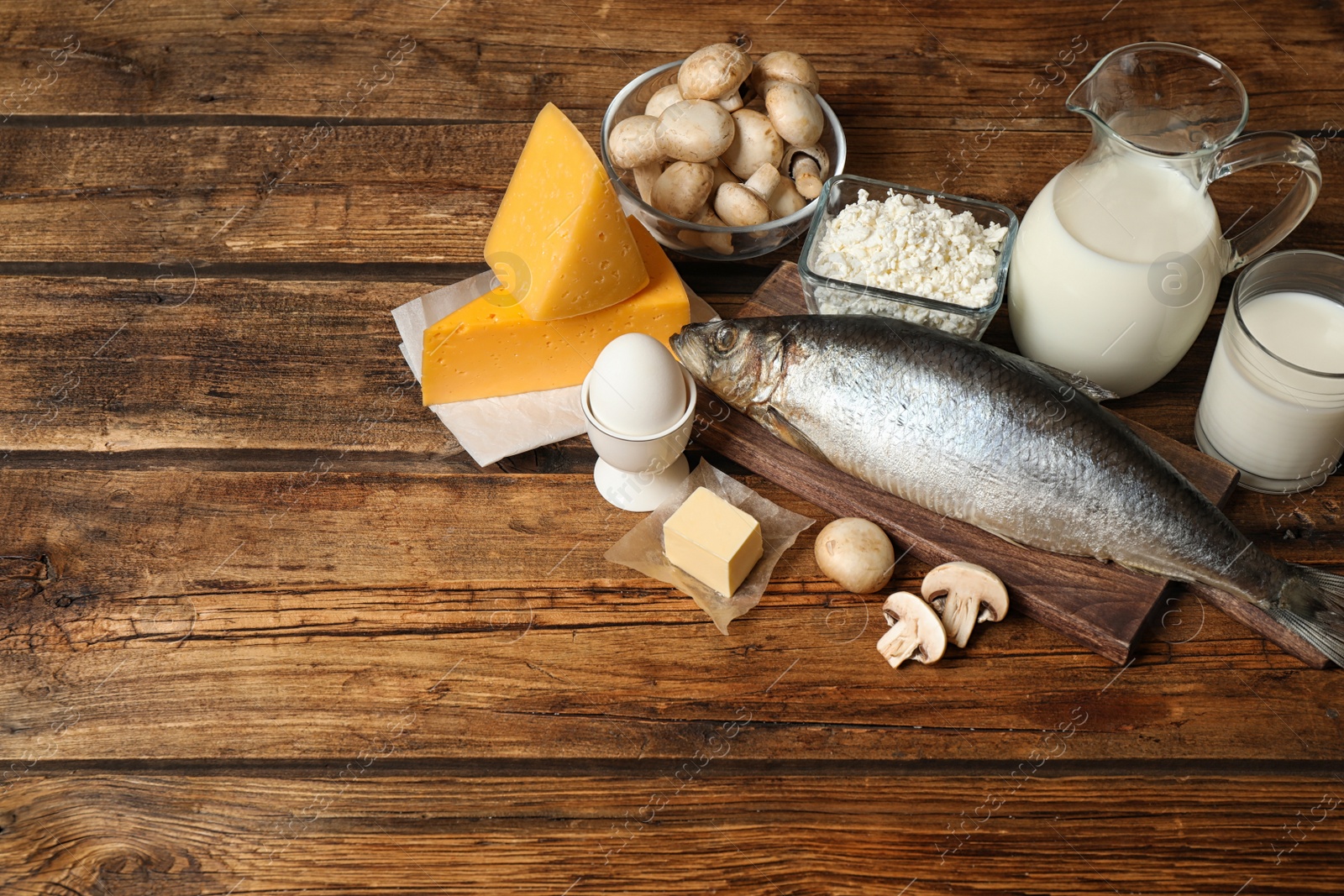 Photo of Fresh products rich in vitamin D on wooden table. Space for text