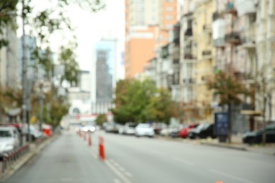 Photo of Blurred view of quiet city with buildings and cars on road