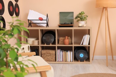 Photo of Vinyl record player on wooden shelving unit indoors