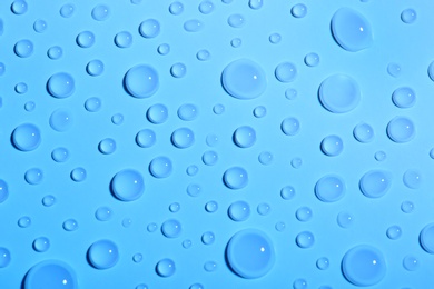 Photo of Water drops on color background, top view