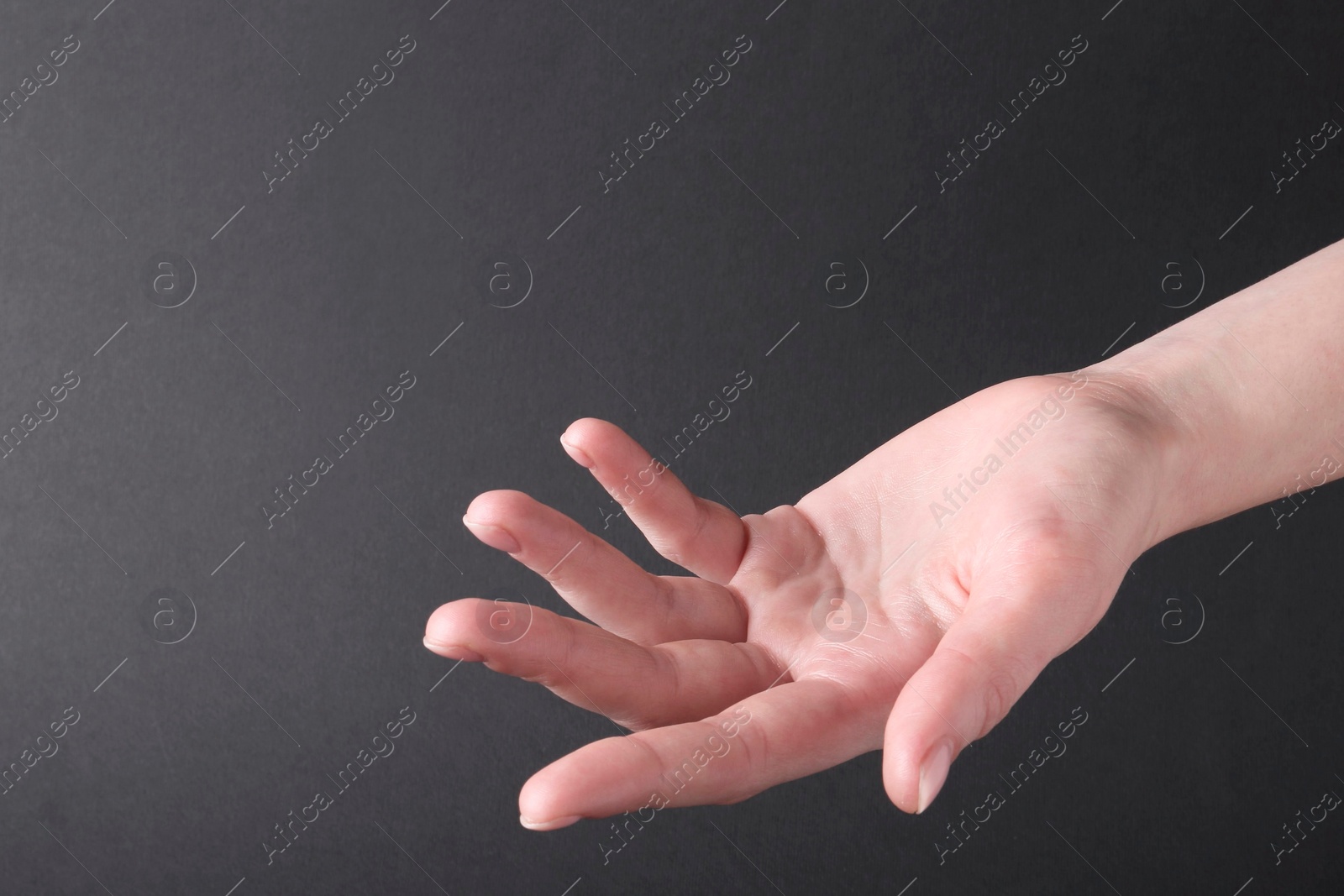 Photo of Woman holding hand on black background, closeup. Space for text