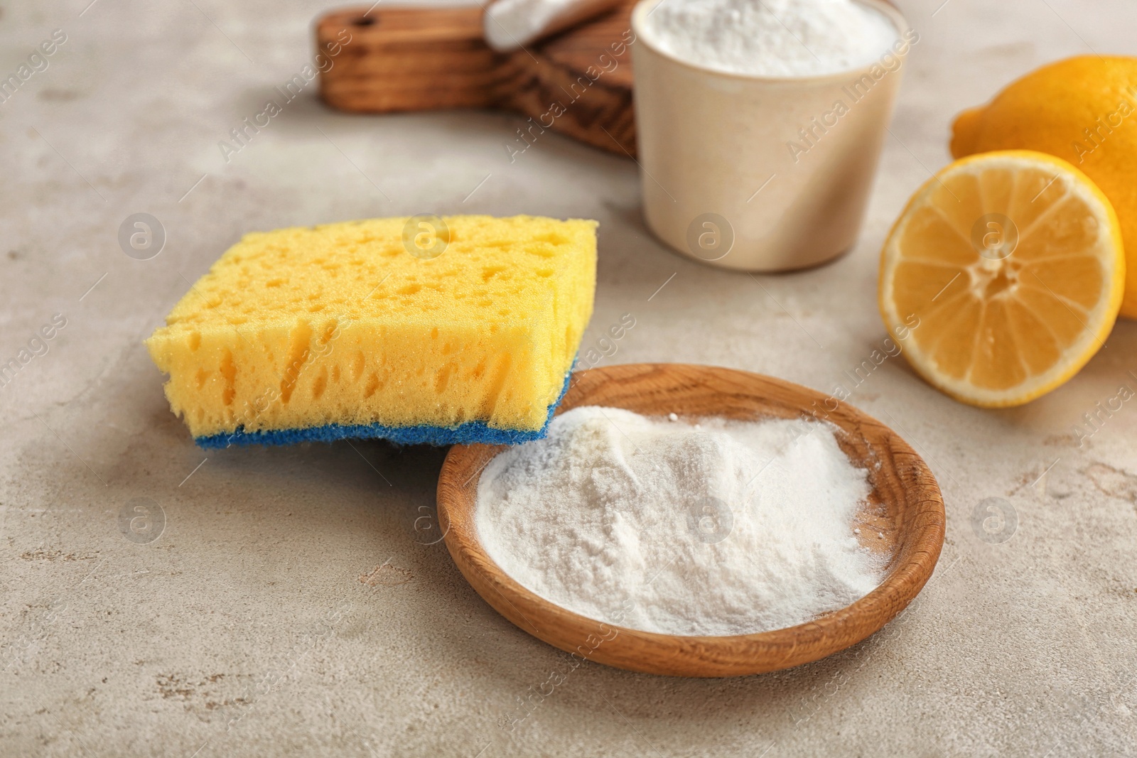 Photo of Bowl with baking soda and sponge on gray table