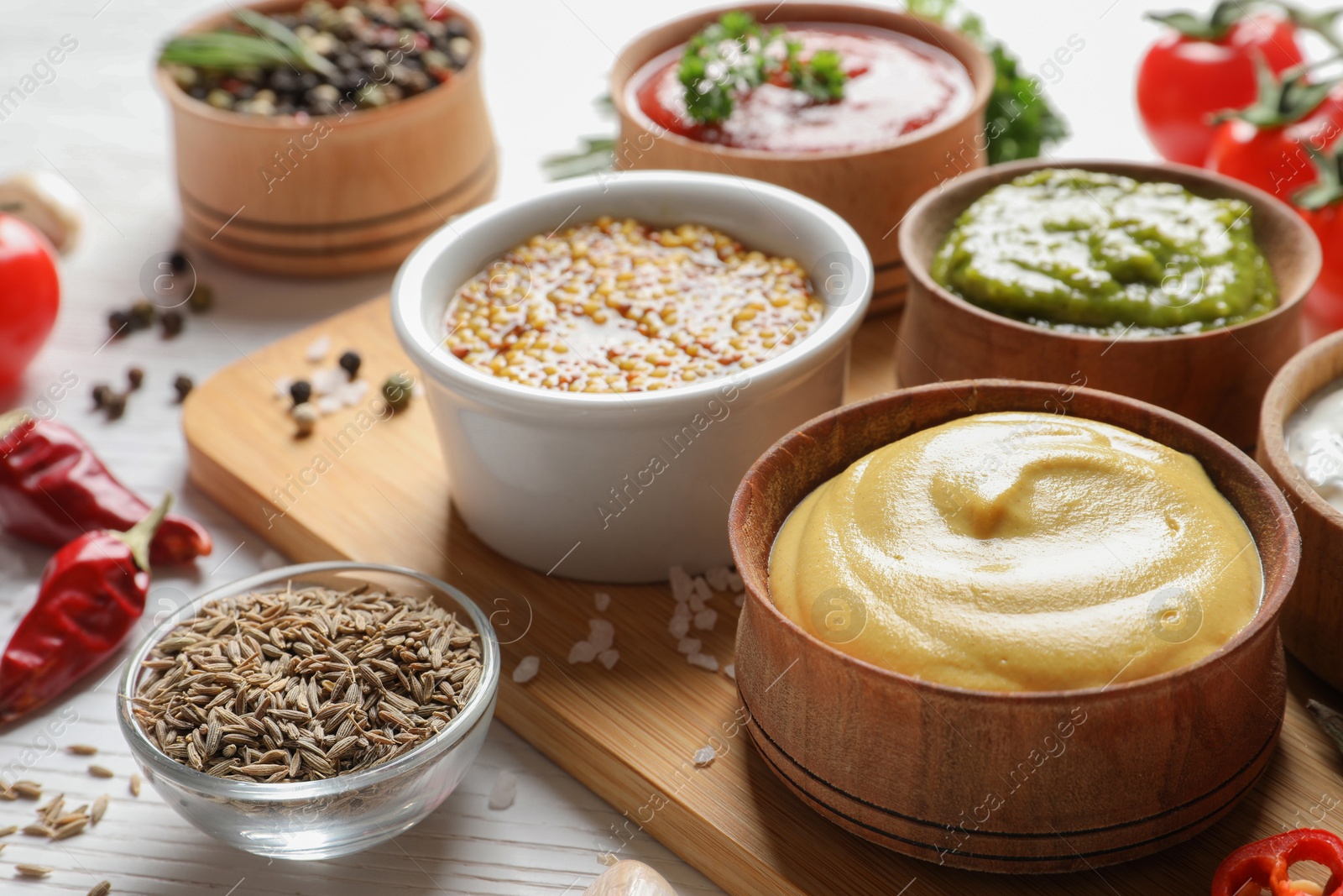 Photo of Board with bowls of different sauces on table