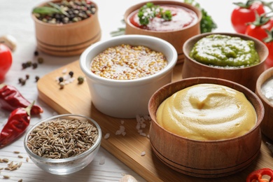 Board with bowls of different sauces on table