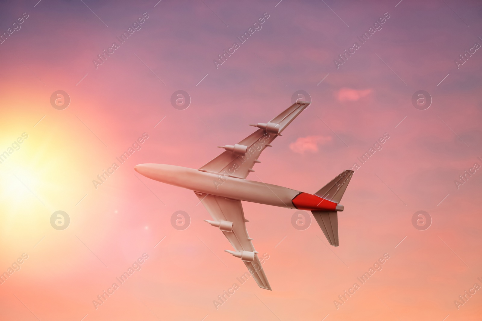 Image of Airplane flying in sky at sunrise. Air transportation