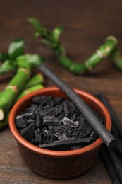 Fresh bamboo and charcoal on wooden table, closeup