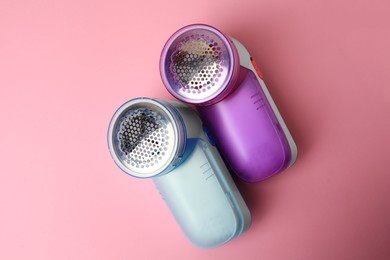 Modern fabric shavers on pink background, flat lay