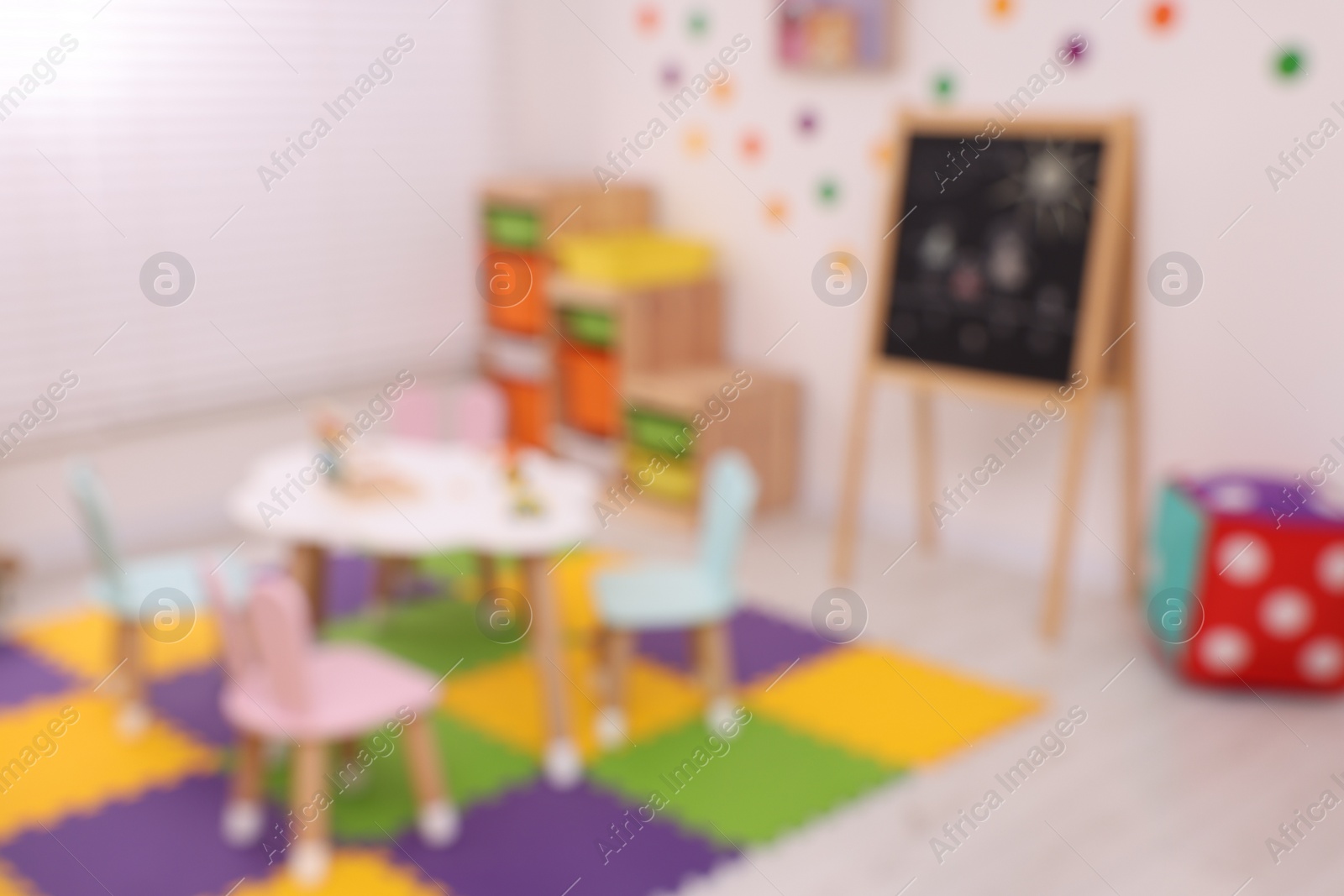 Photo of Stylish kindergarten interior with toys and modern furniture, blurred view