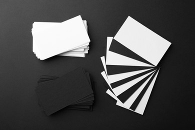 Photo of Blank business cards on black background, flat lay. Mockup for design