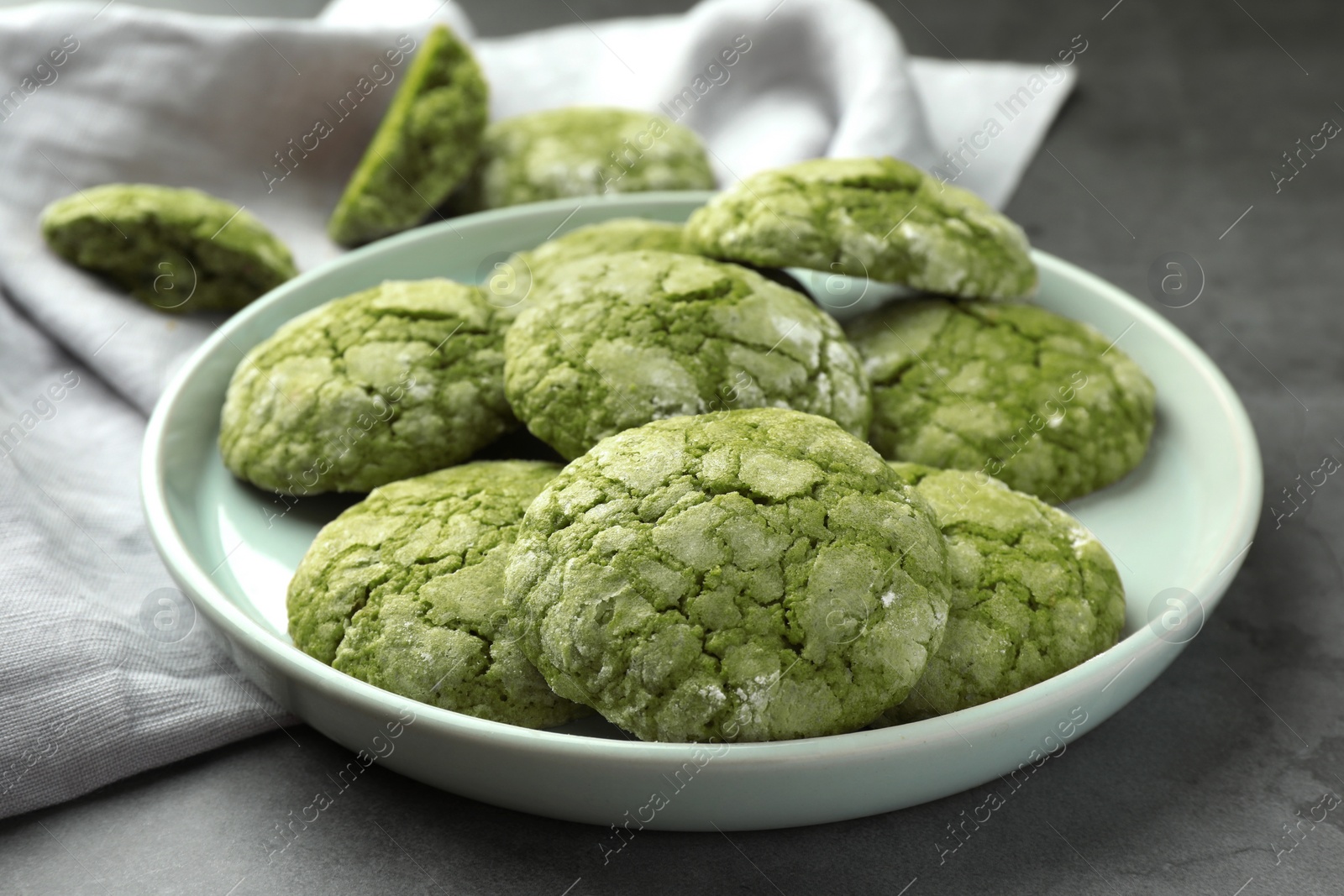 Photo of Plate with tasty matcha cookies on grey table, closeup