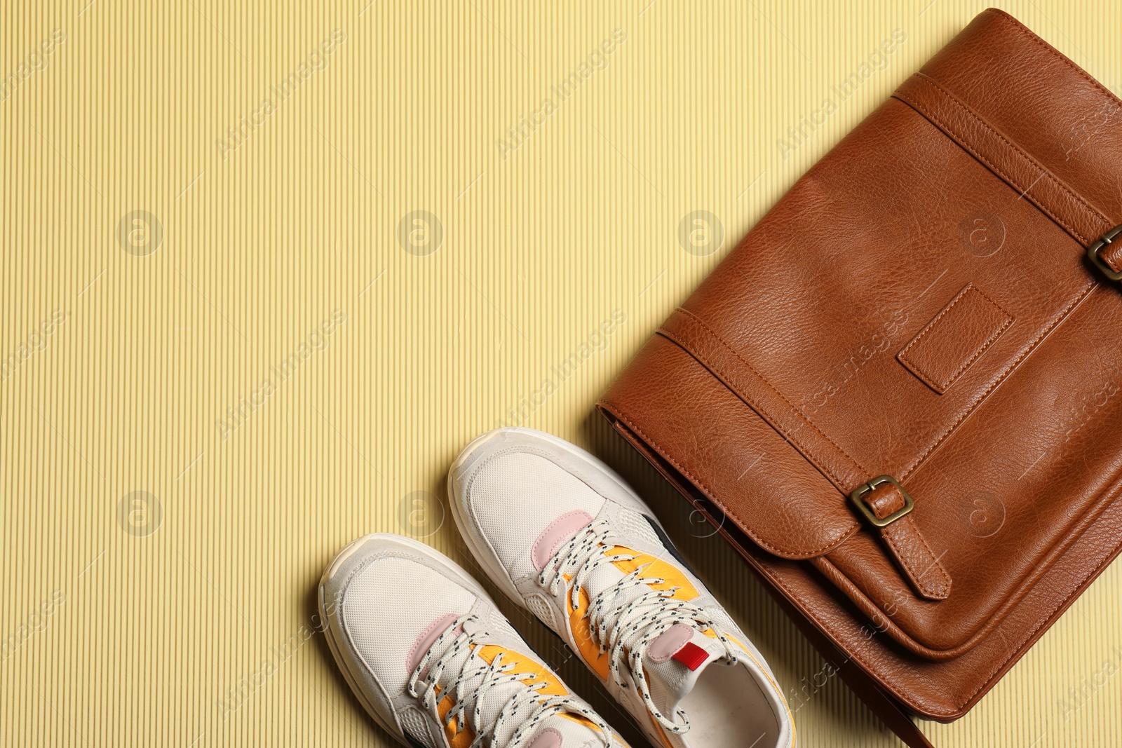 Photo of Pair of sport shoes and bag on color background, top view with space for text