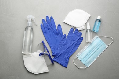 Photo of Flat lay composition with medical gloves, masks and hand sanitizers on grey background