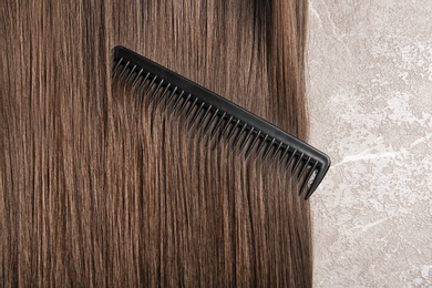 Photo of Beautiful hair and comb on grey background, top view