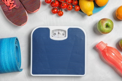 Photo of Flat lay composition with scales, healthy food and sport equipment on light background. Weight loss