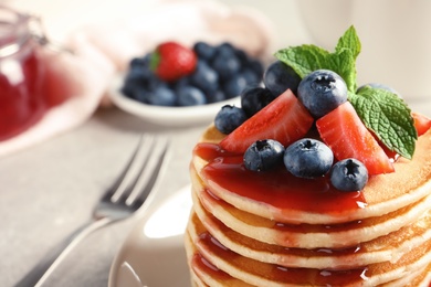 Photo of Plate with pancakes and berries on table, closeup