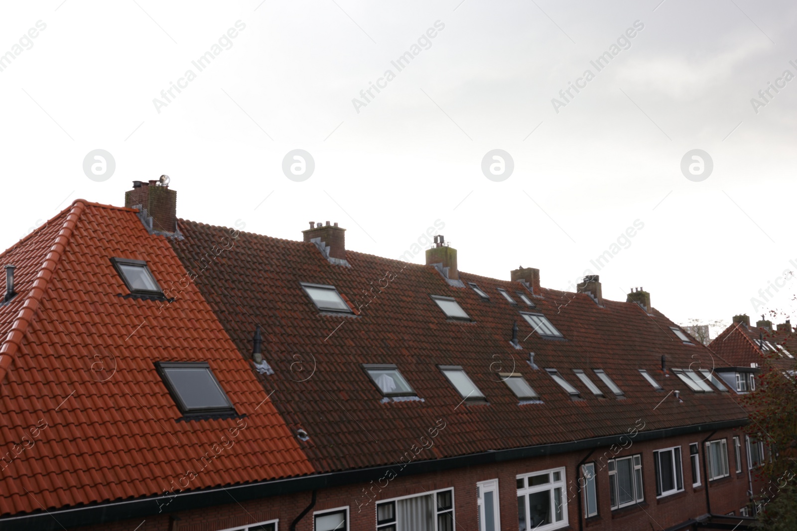 Photo of Beautiful building with tiled roof and chimneys in city under sky