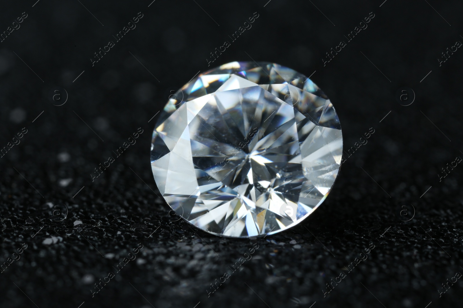 Photo of Beautiful shiny diamond on black background, closeup