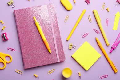 Photo of Bright school stationery on lilac background, flat lay