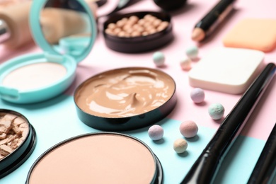 Composition with powder, skin foundation and beauty accessories on color background