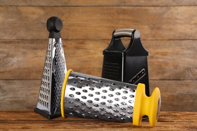 Photo of Different stainless steel graters on wooden table
