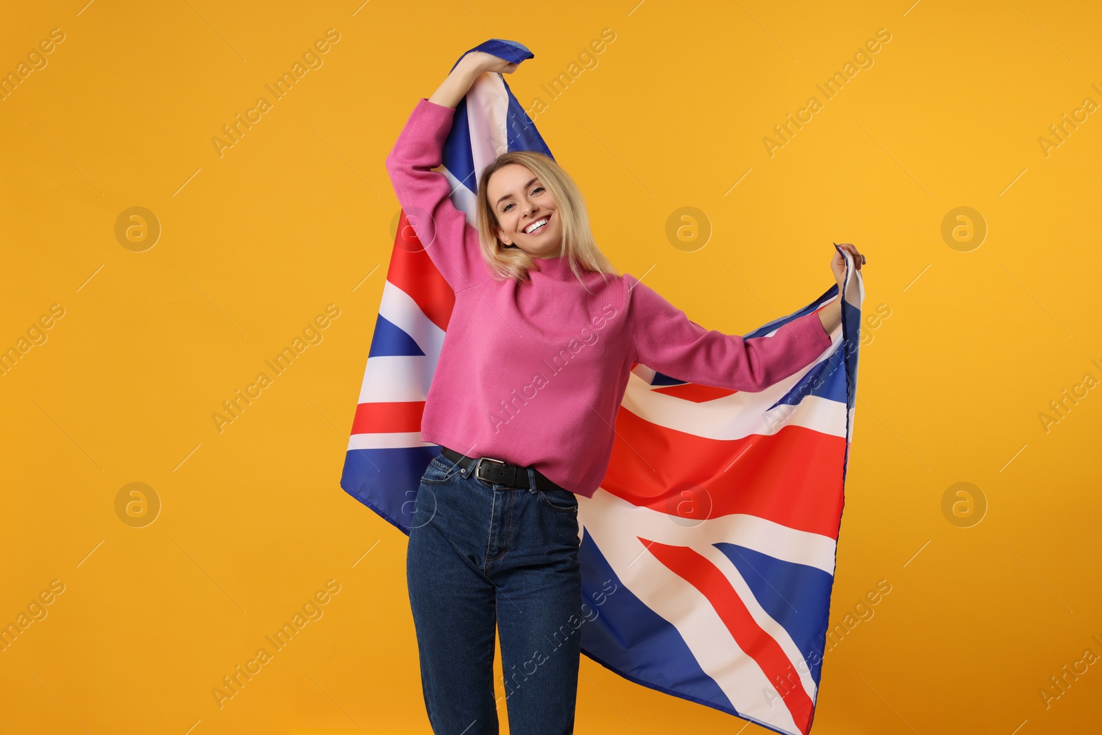 Photo of Happy woman with flag of United Kingdom on orange background