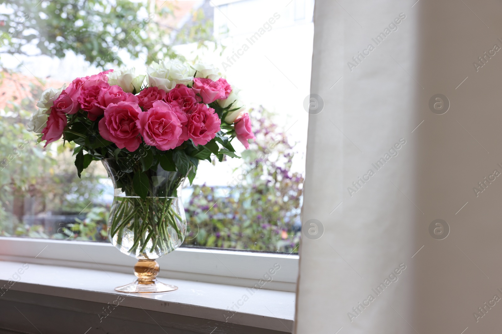 Photo of Vase with beautiful bouquet of roses on windowsill indoors, space for text