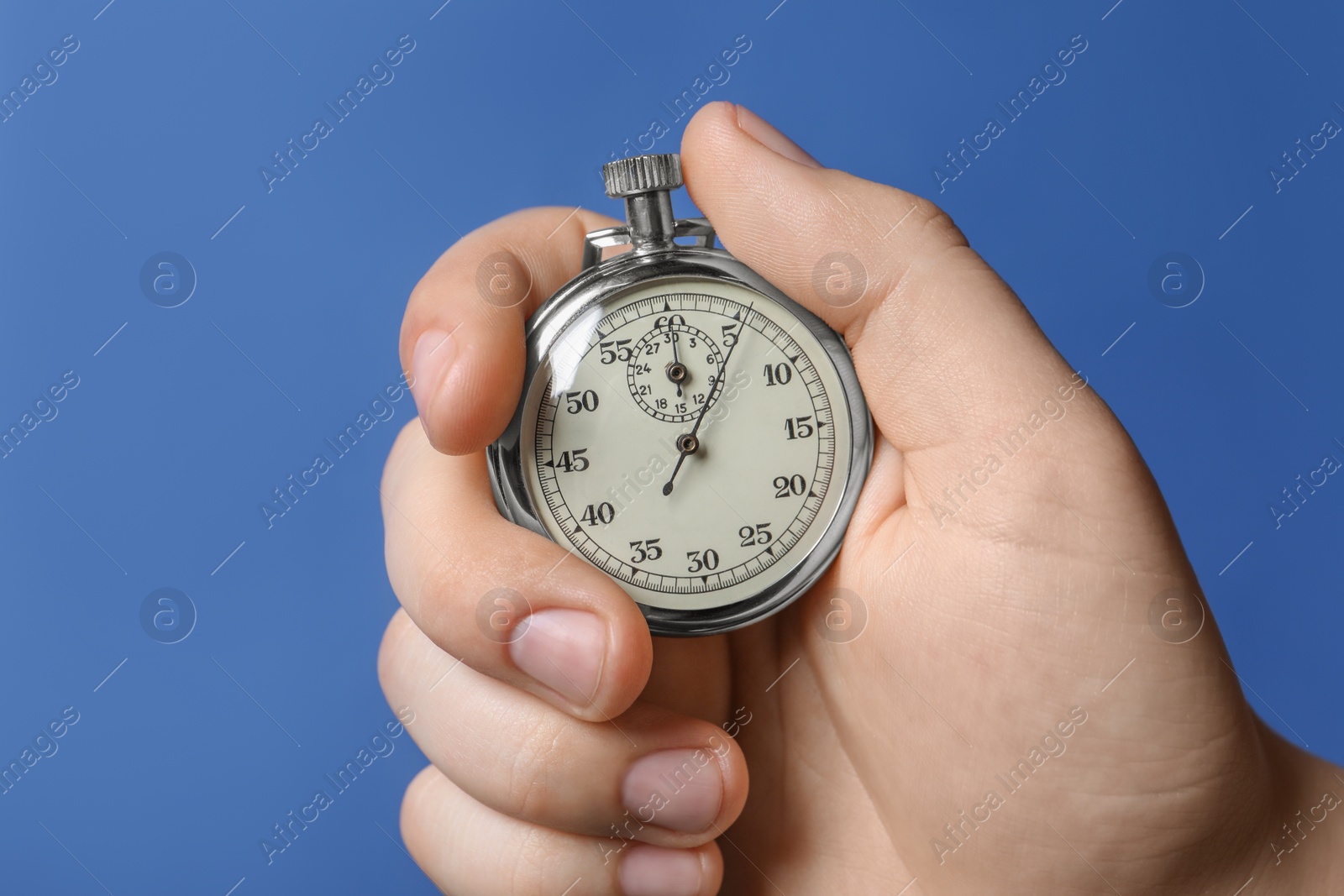 Photo of Man holding vintage timer on blue background, closeup