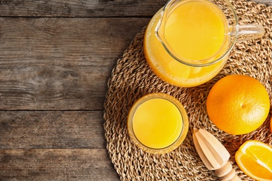 Photo of Composition with fresh orange juice on wooden background, flat lay. Space for text