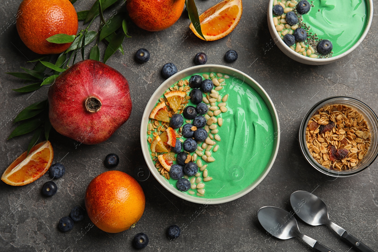 Photo of Flat lay composition with bowls of spirulina smoothie on grey background