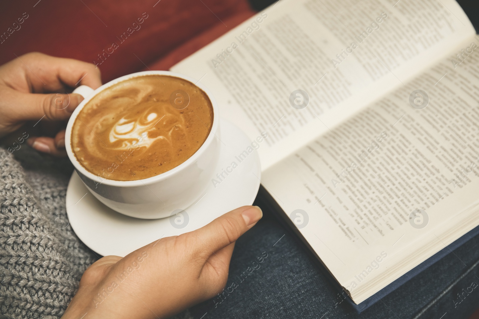 Image of Woman with cup of coffee reading book, closeup