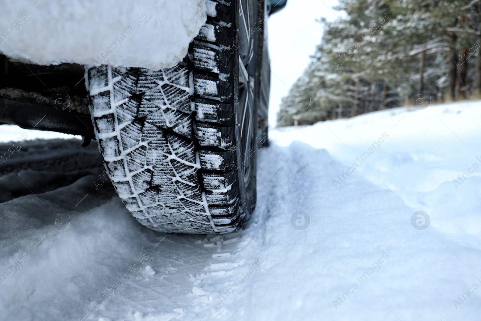 Photo of Snowy country road with car on winter day, closeup with space for text