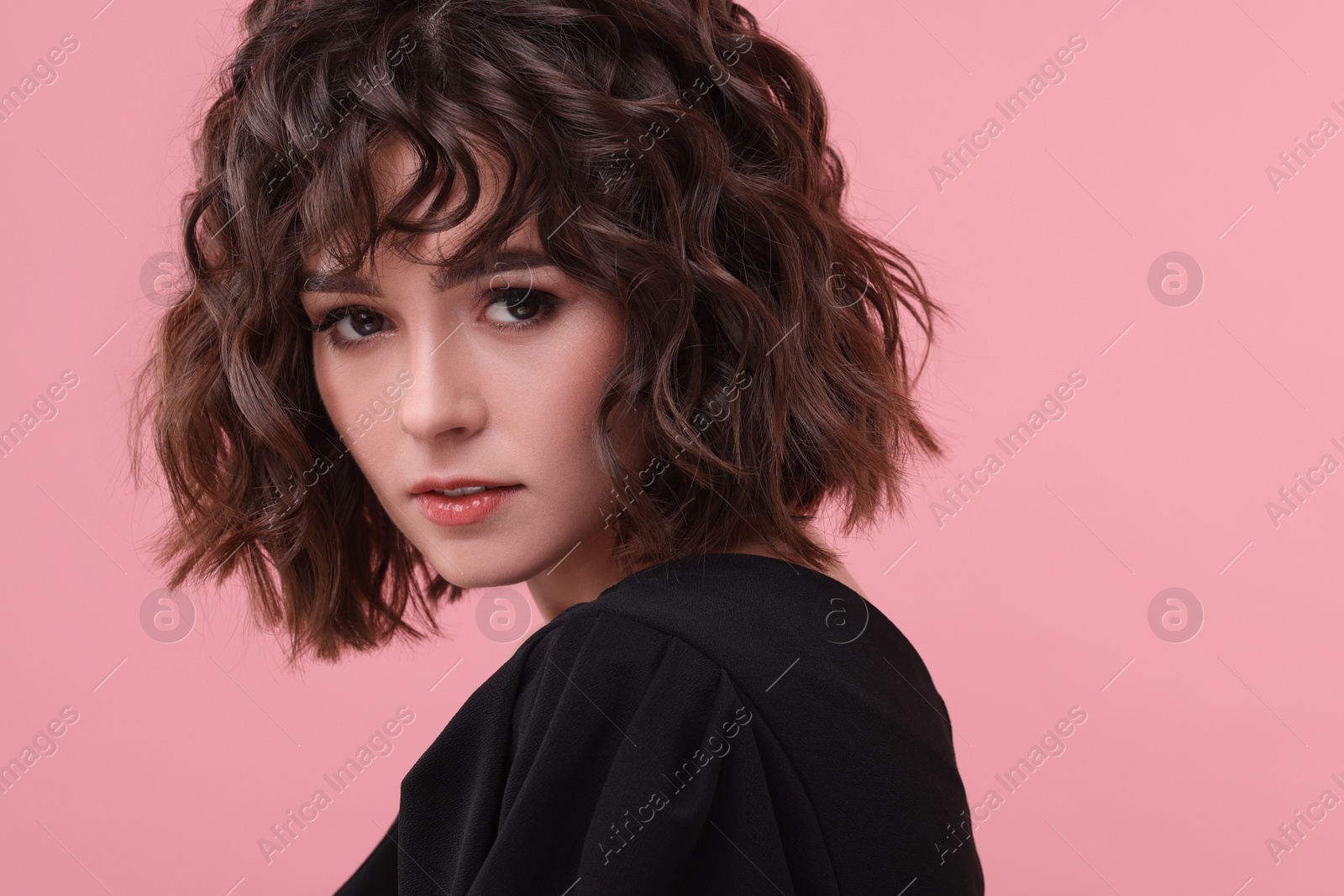 Photo of Portrait of beautiful young woman with wavy hairstyle on pink background. Space for text