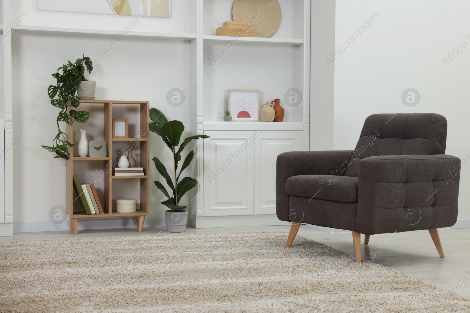 Photo of Stylish room interior with armchair and houseplants